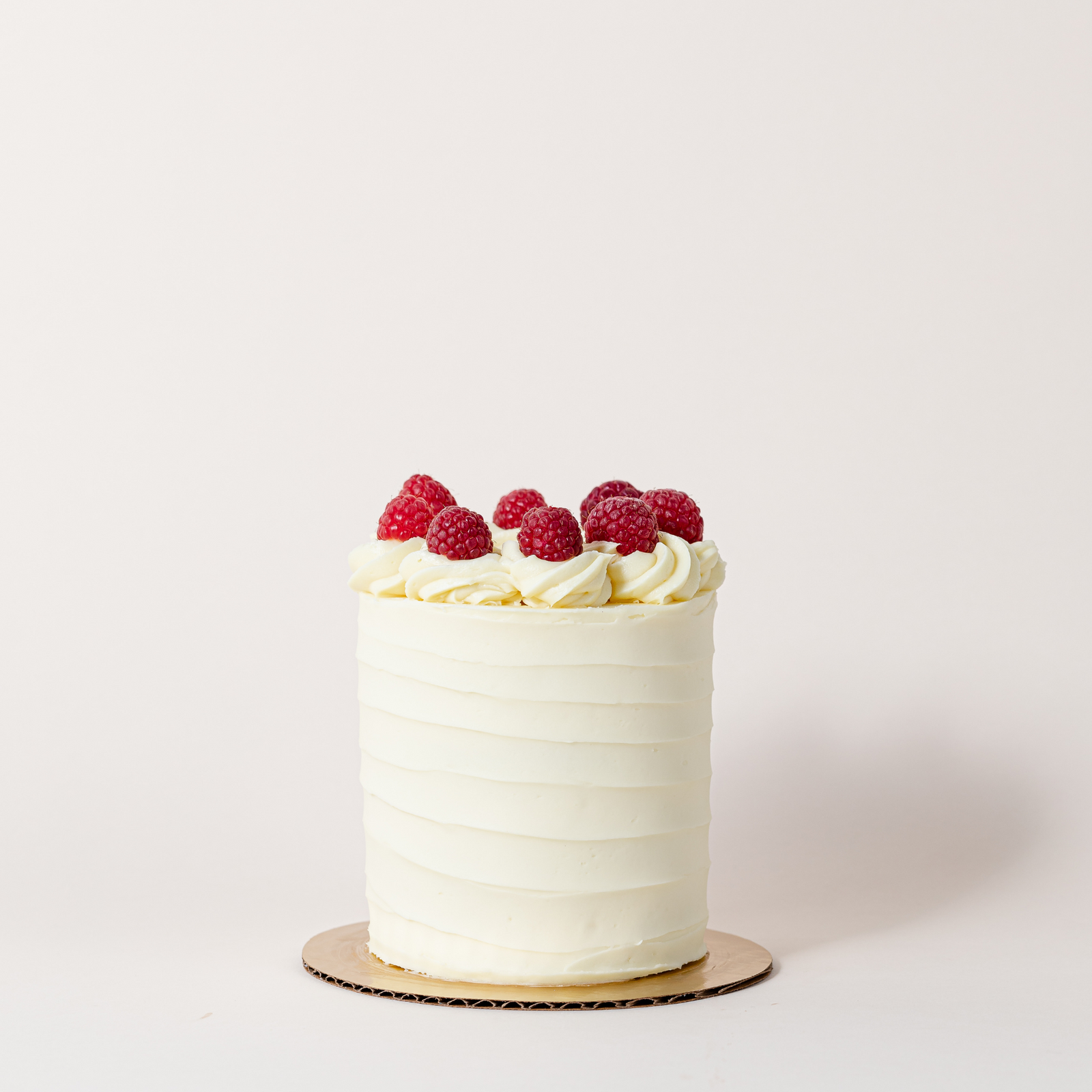 Lemon berry cake topped with a fresh raspberry crown