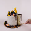 Construction-themed birthday cake with toy trucks and a slice being cut, on a white background